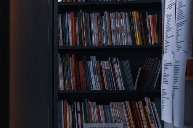 Huge number of various literature on shelves behind open door of modern public library