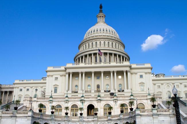 The United States Capitol Building in Washington, DC, with a clear blue sky.